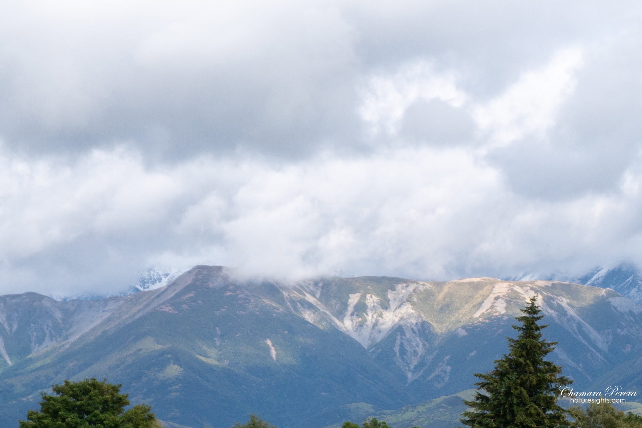 Southern Alps mountain peaks through clouds TranzAlpine New Zealand
