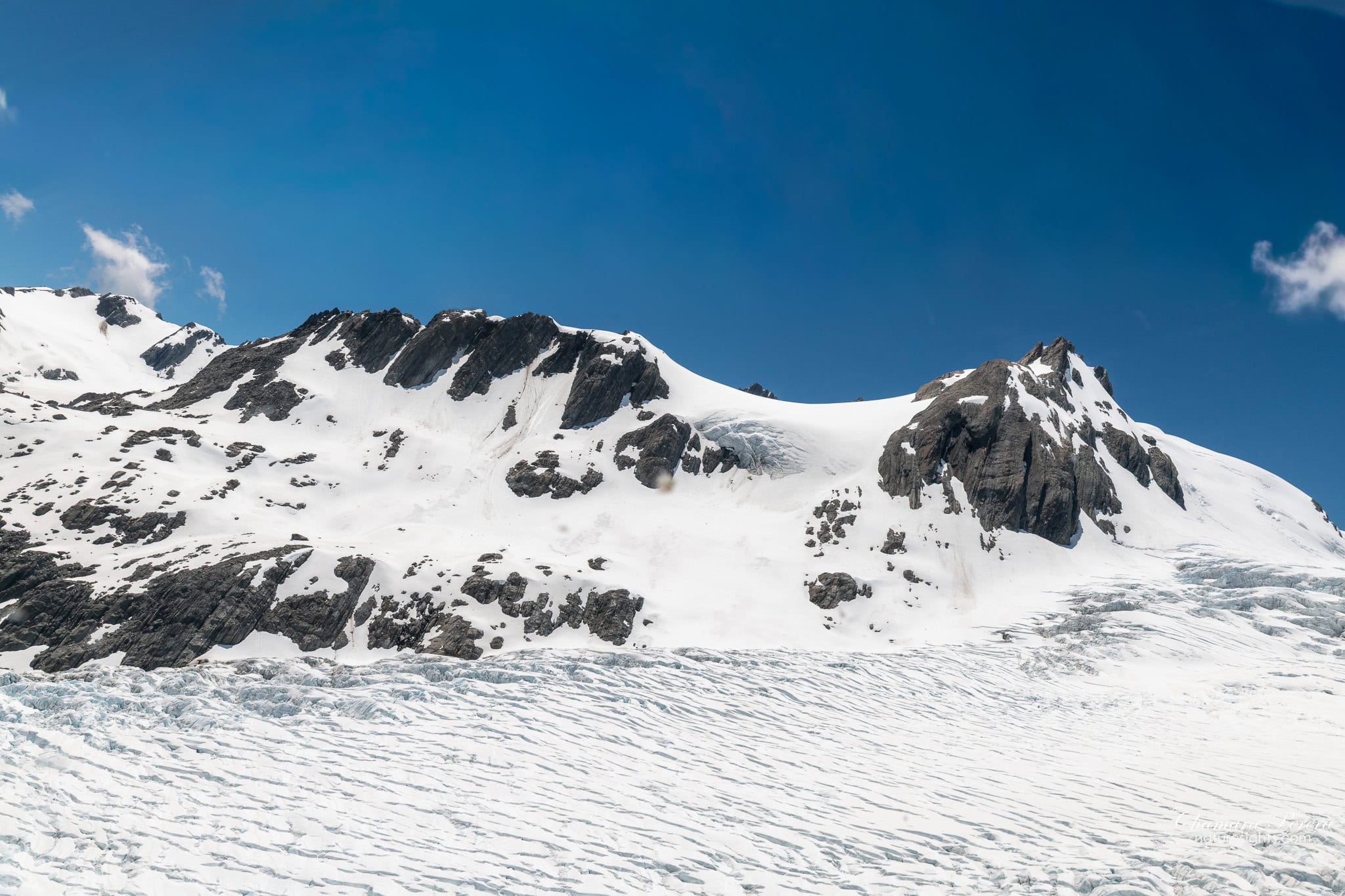 Franz Josef Glacier upper snowfield with rocky peaks New Zealand