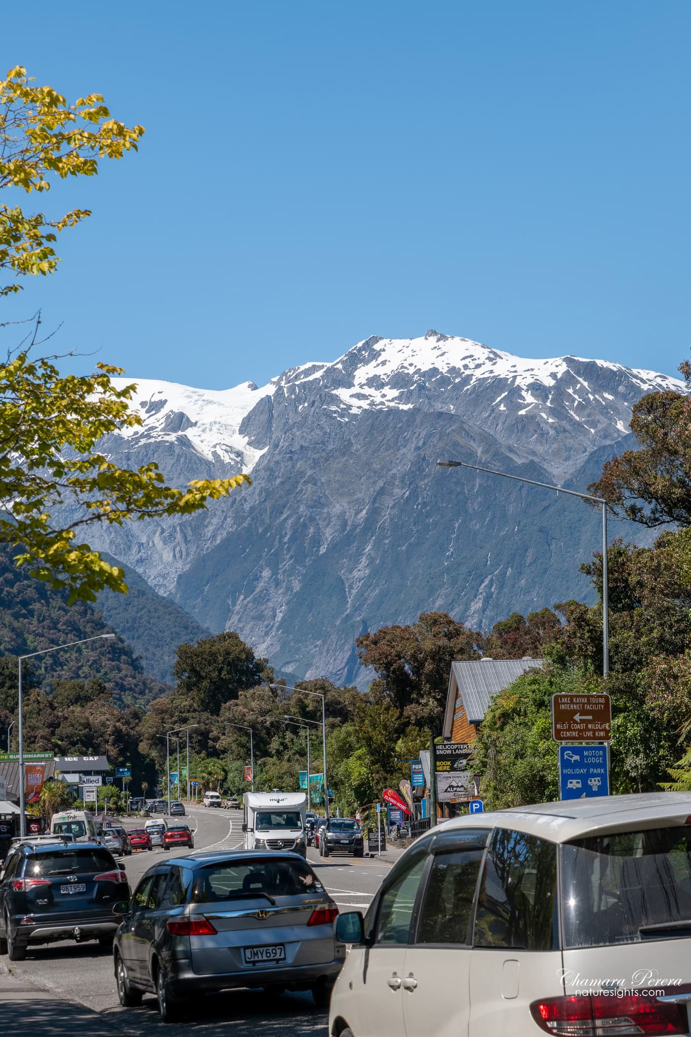 Franz Josef village main street with snow-capped Southern Alps New Zealand