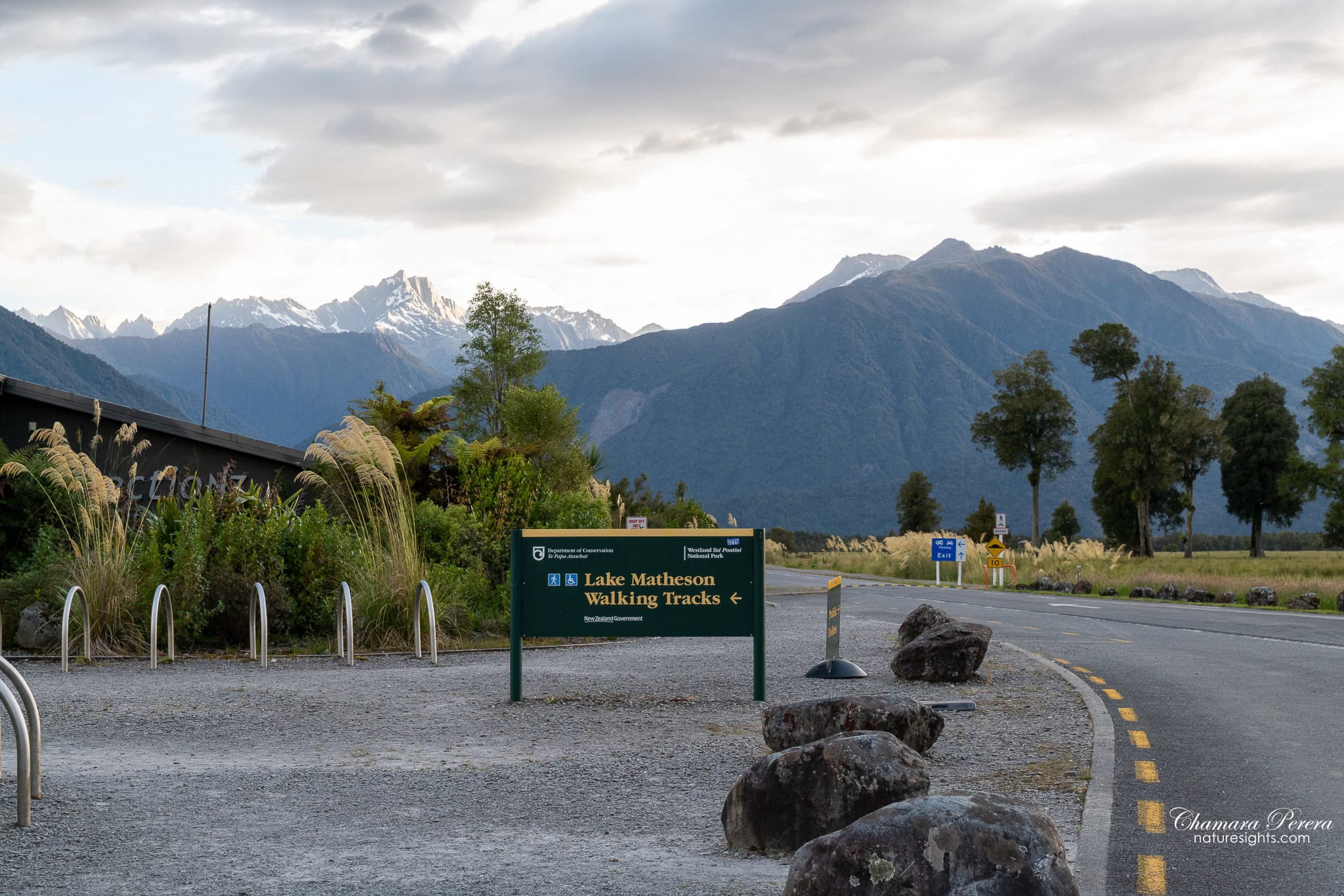 Lake Matheson Walking Tracks sign at car park with Southern Alps Fox Glacier New Zealand