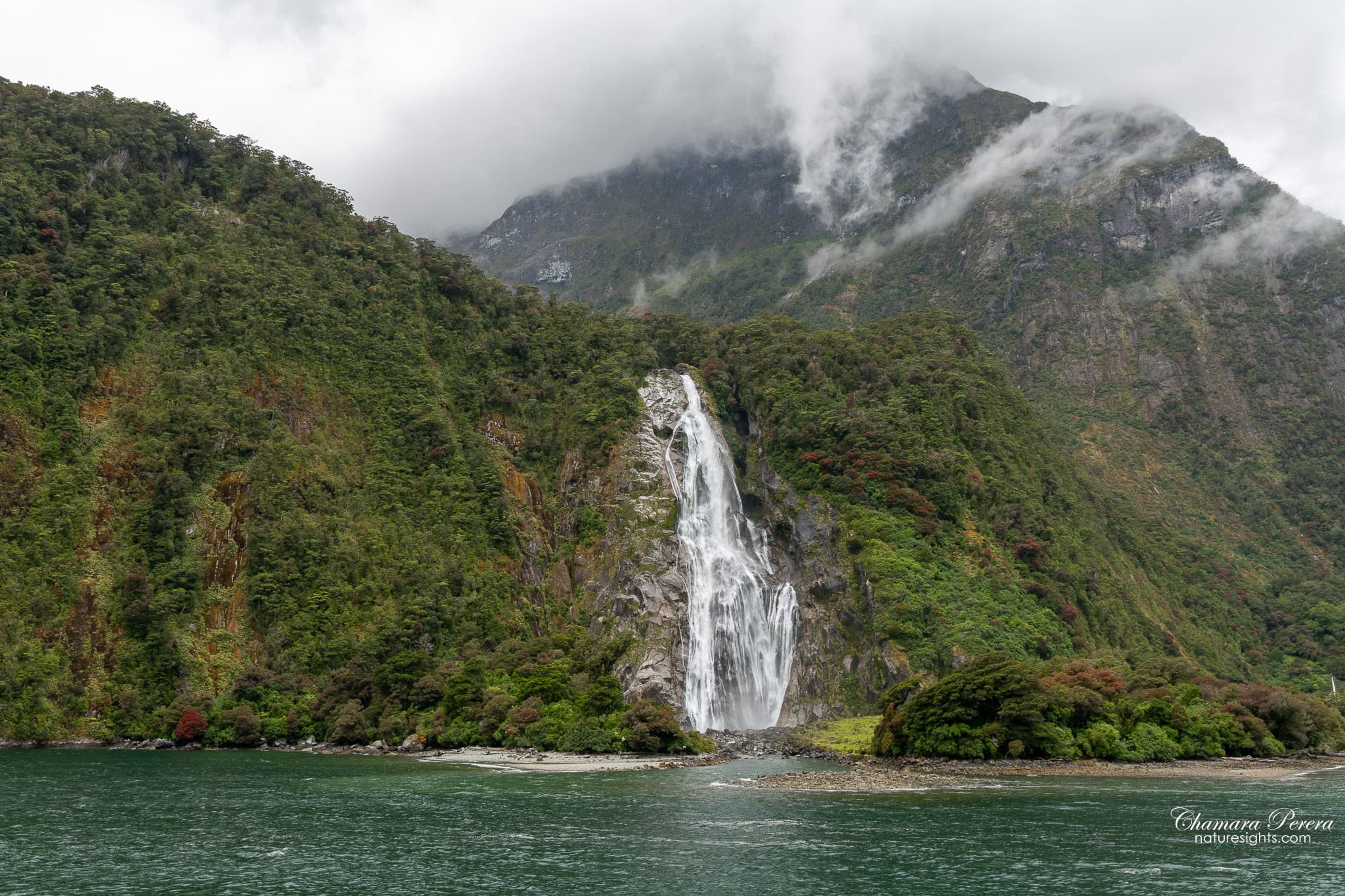 Milford Sound waterfall with mountain behind New Zealand