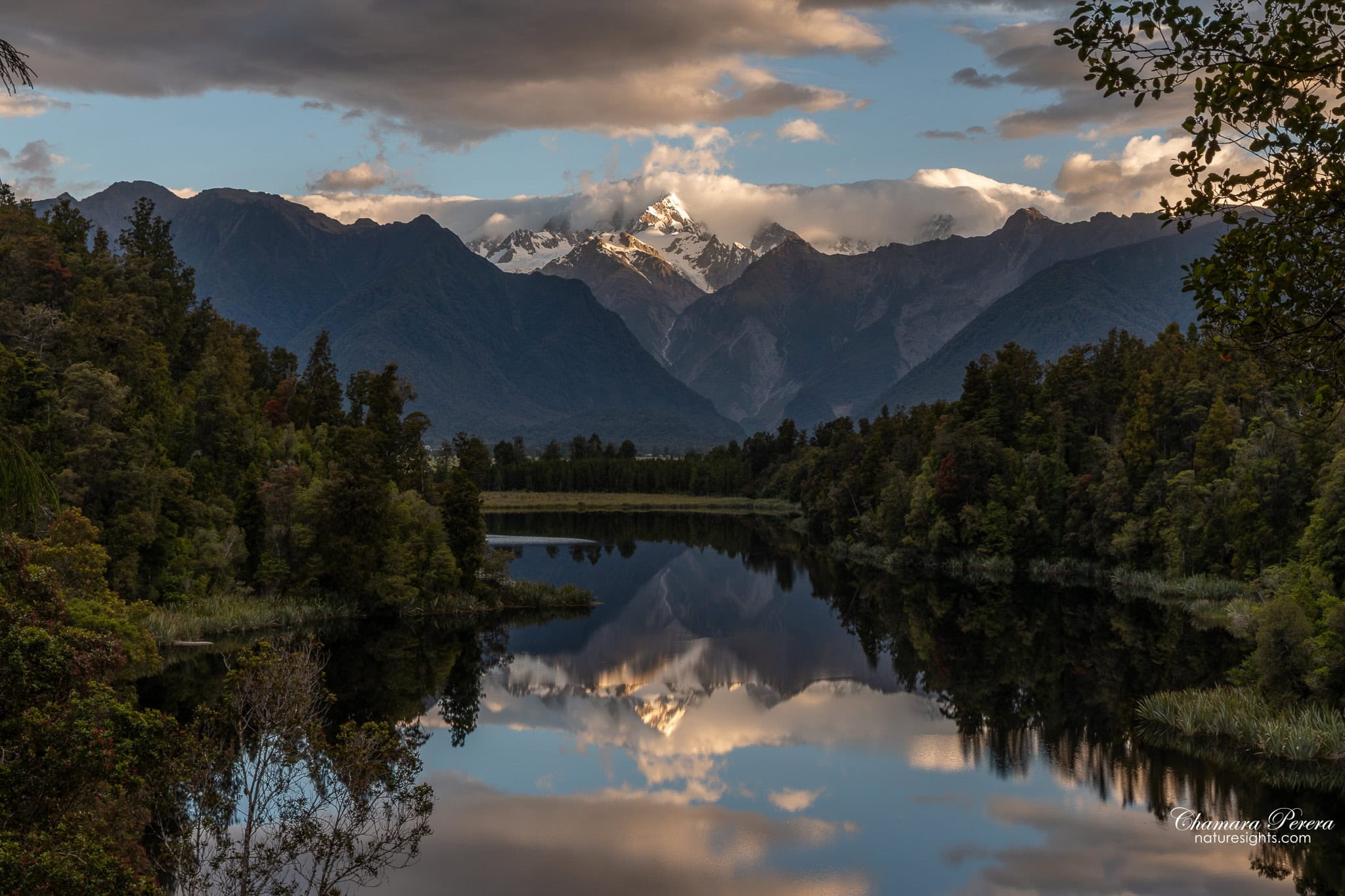 Mount Cook and Mount Tasman catching golden light reflected in Lake Matheson New Zealand