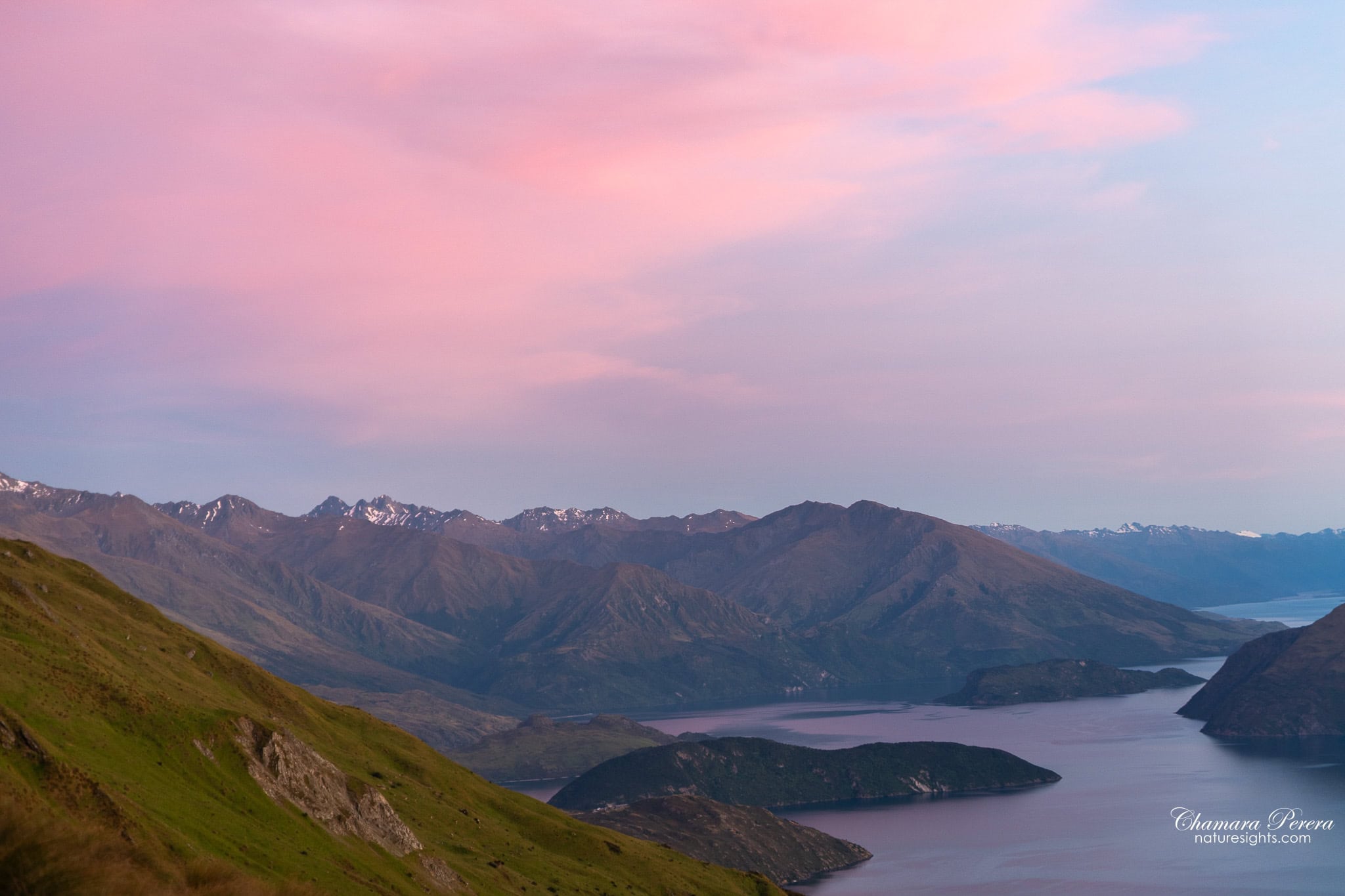 Pastel pink and blue dawn sky over Lake Wanaka from Roy's Peak ridge New Zealand