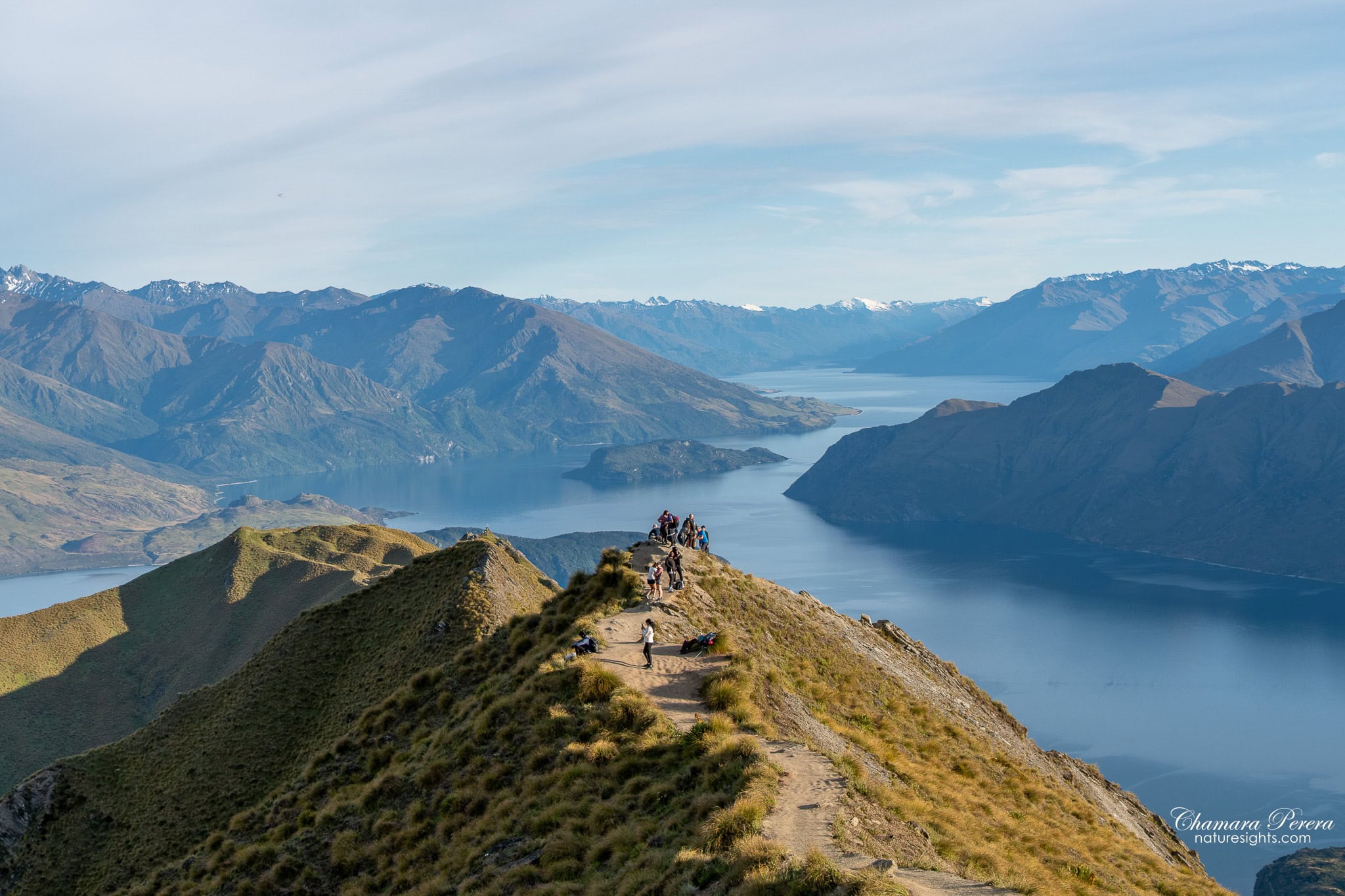 Hikers at Roy's Peak viewpoint overlooking Lake Wanaka New Zealand