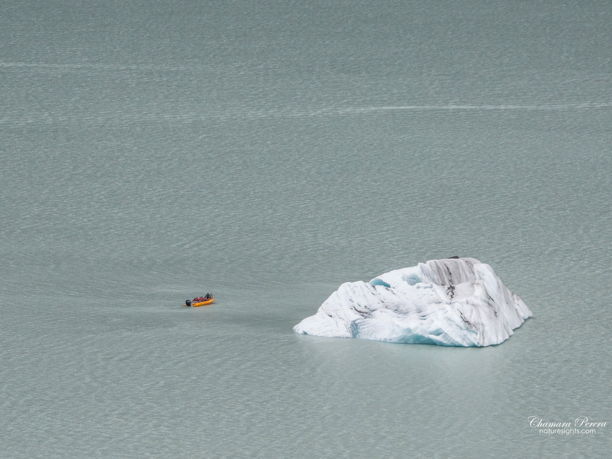 Glacier Explorers zodiac boat alongside large iceberg on Tasman Lake Mount Cook New Zealand