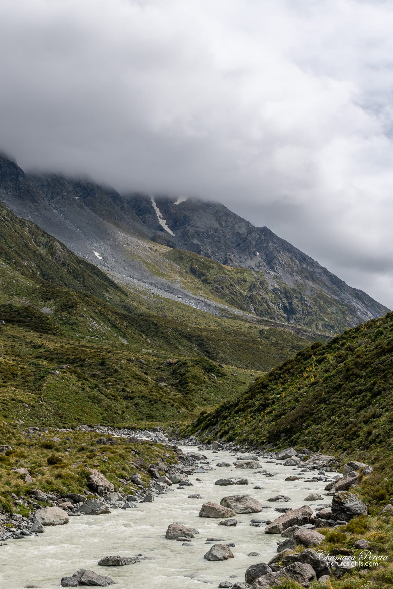 Hooker River boulders with mountain and cloud behind Mount Cook New Zealand