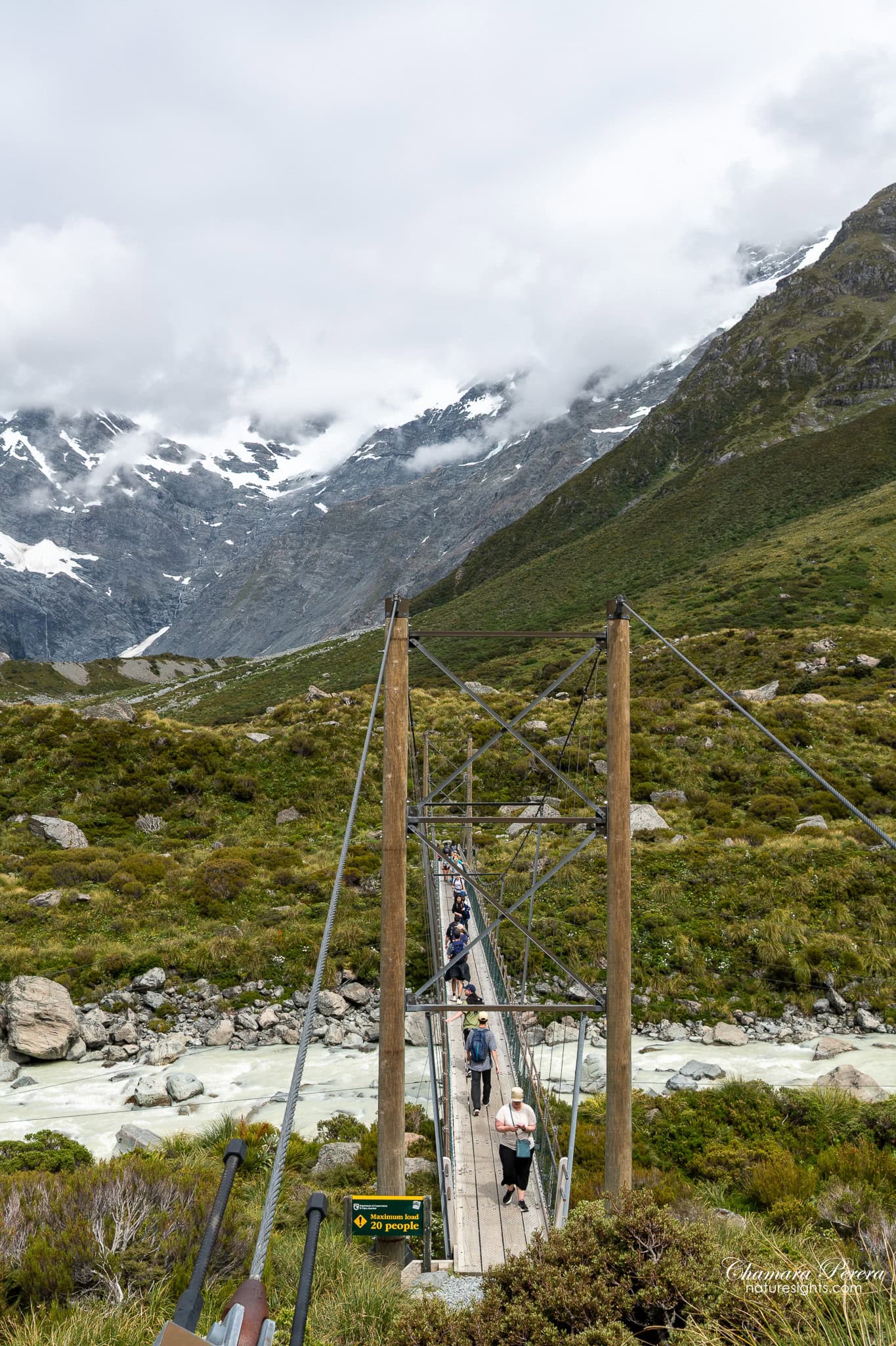 swing bridge on Hooker Valley Track with people crossing Mount Cook New Zealand