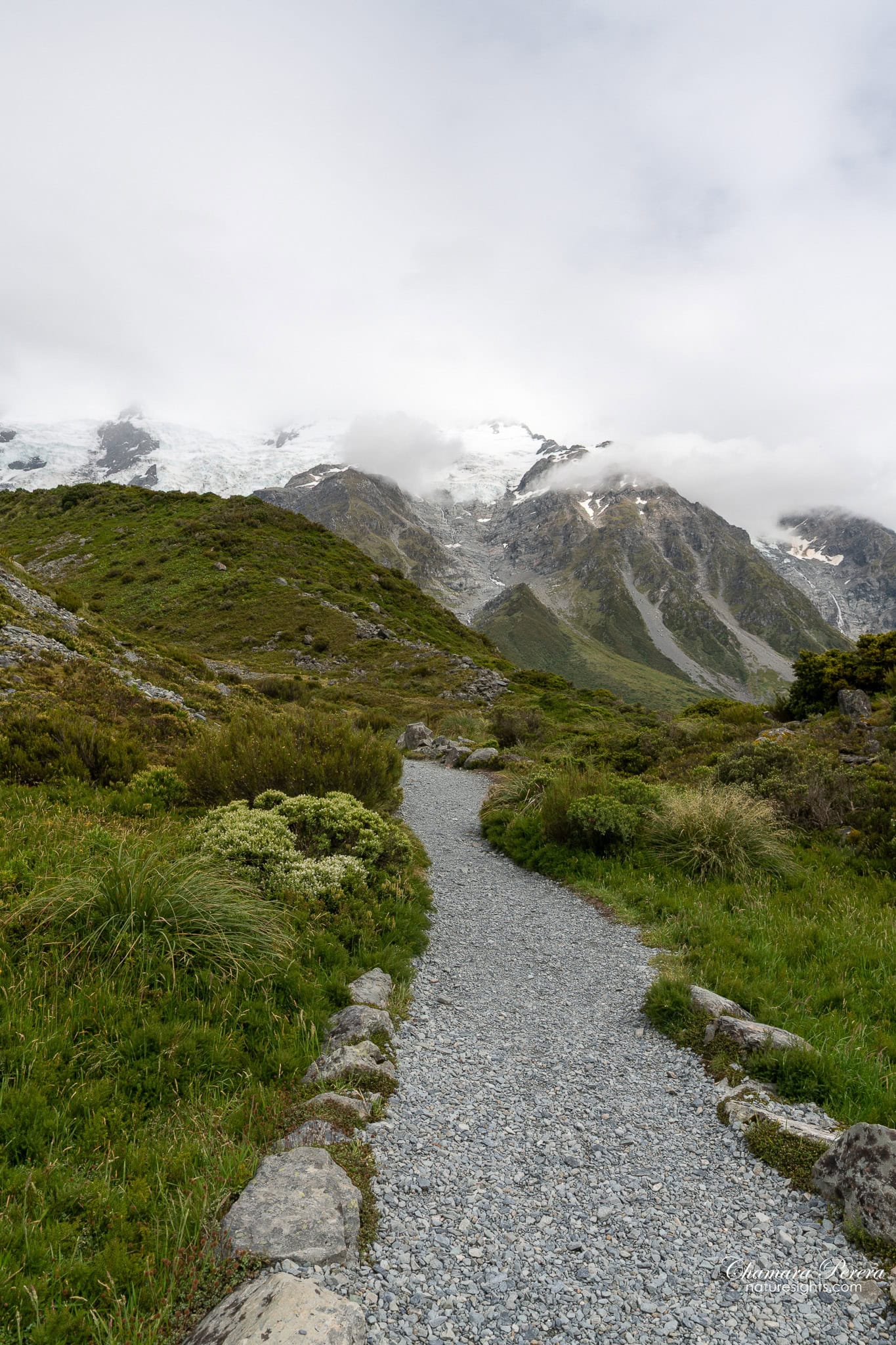 gravel path on Hooker Valley Track with mountains and cloud Mount Cook New Zealand