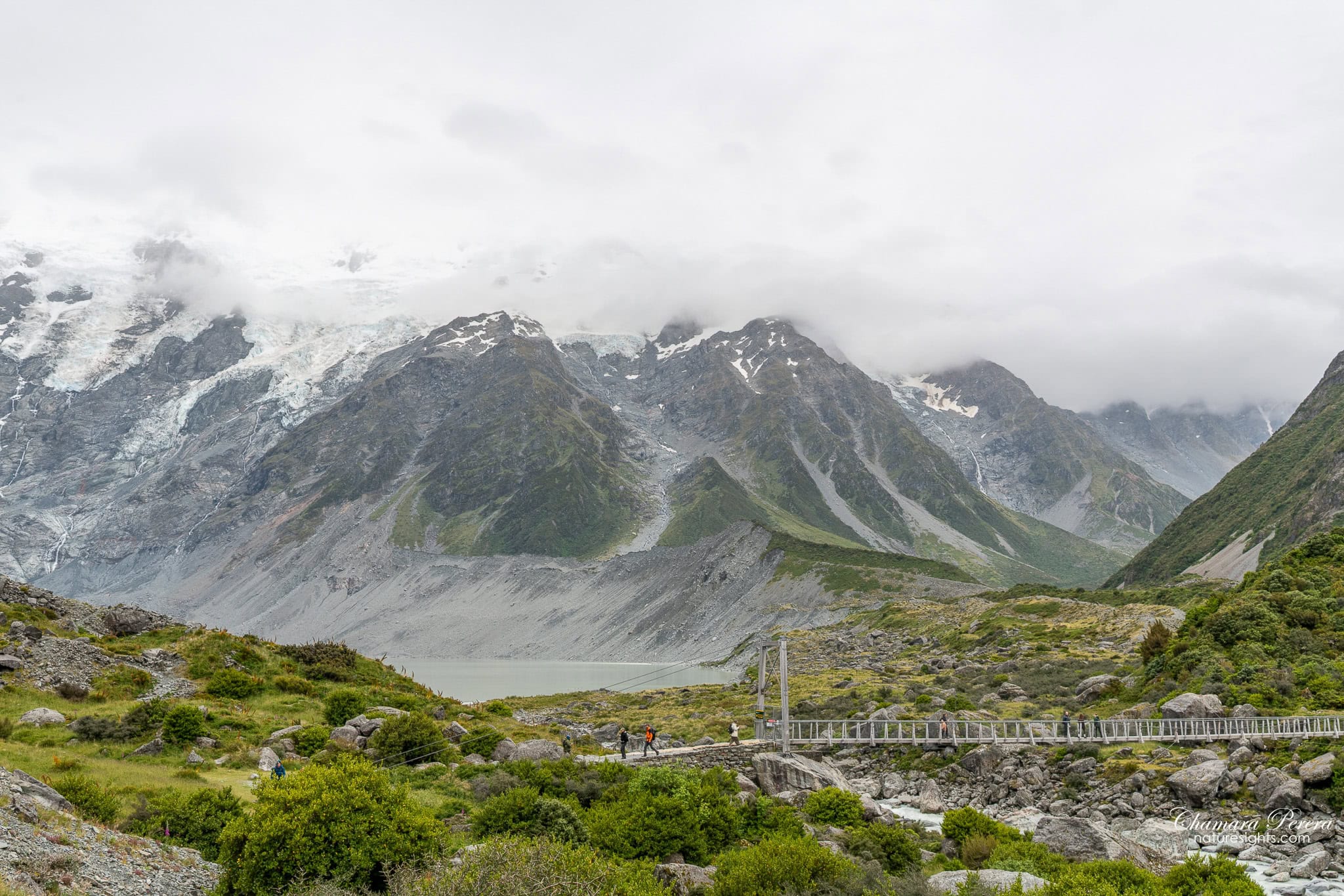 swing bridge on Hooker Valley Track with glacial lake visible Mount Cook New Zealand