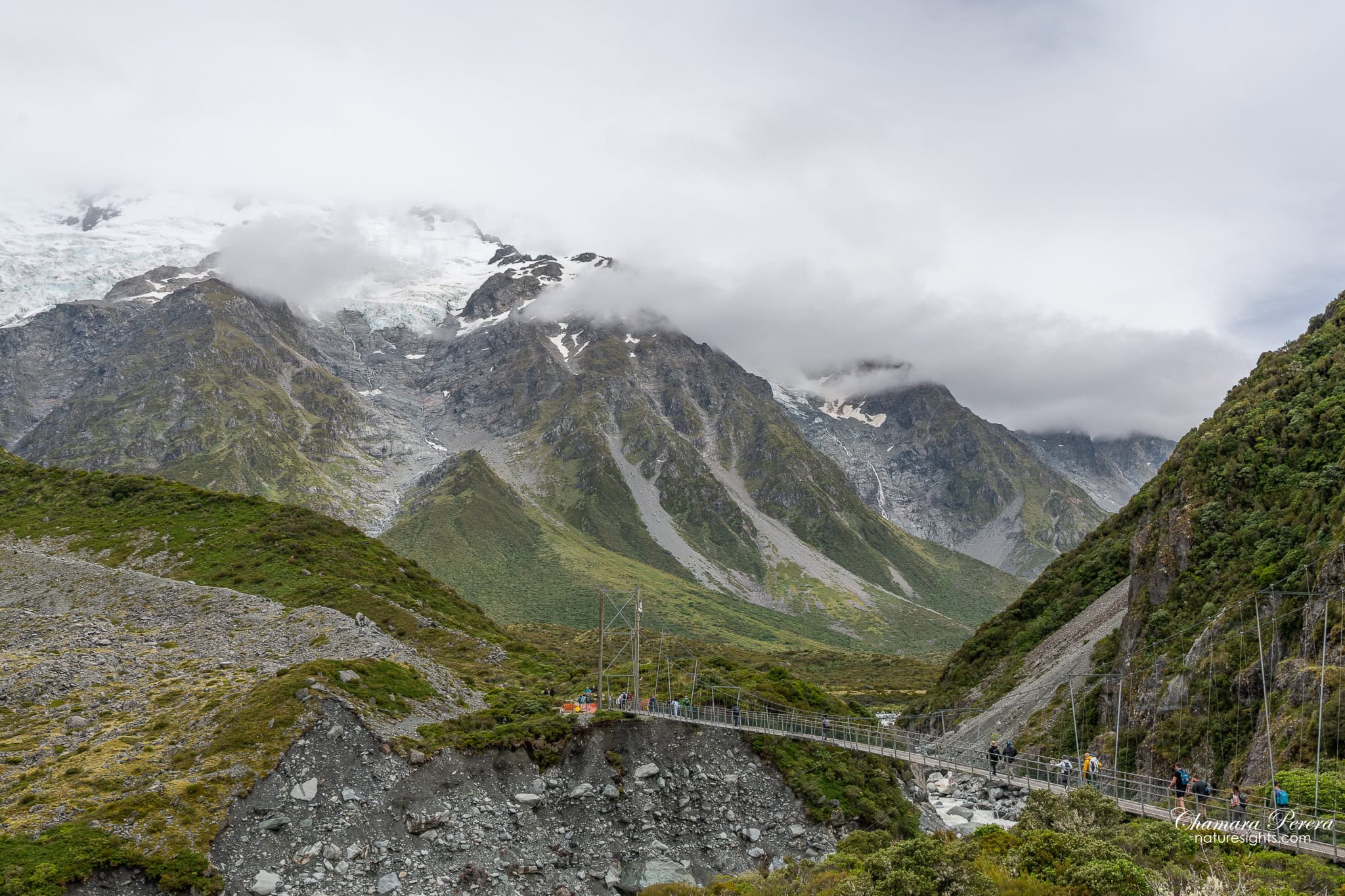 suspension swing bridge on Hooker Valley Track with mountains Mount Cook New Zealand